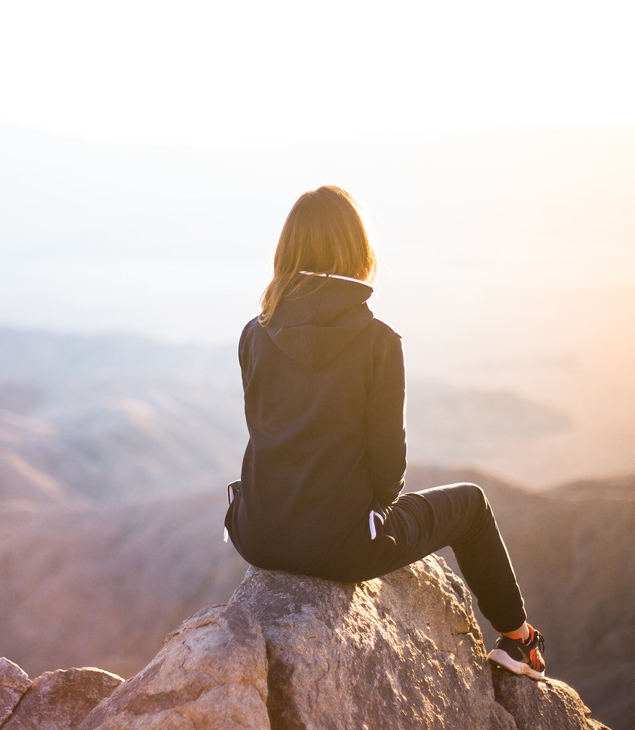 Femme assise sur un rocher